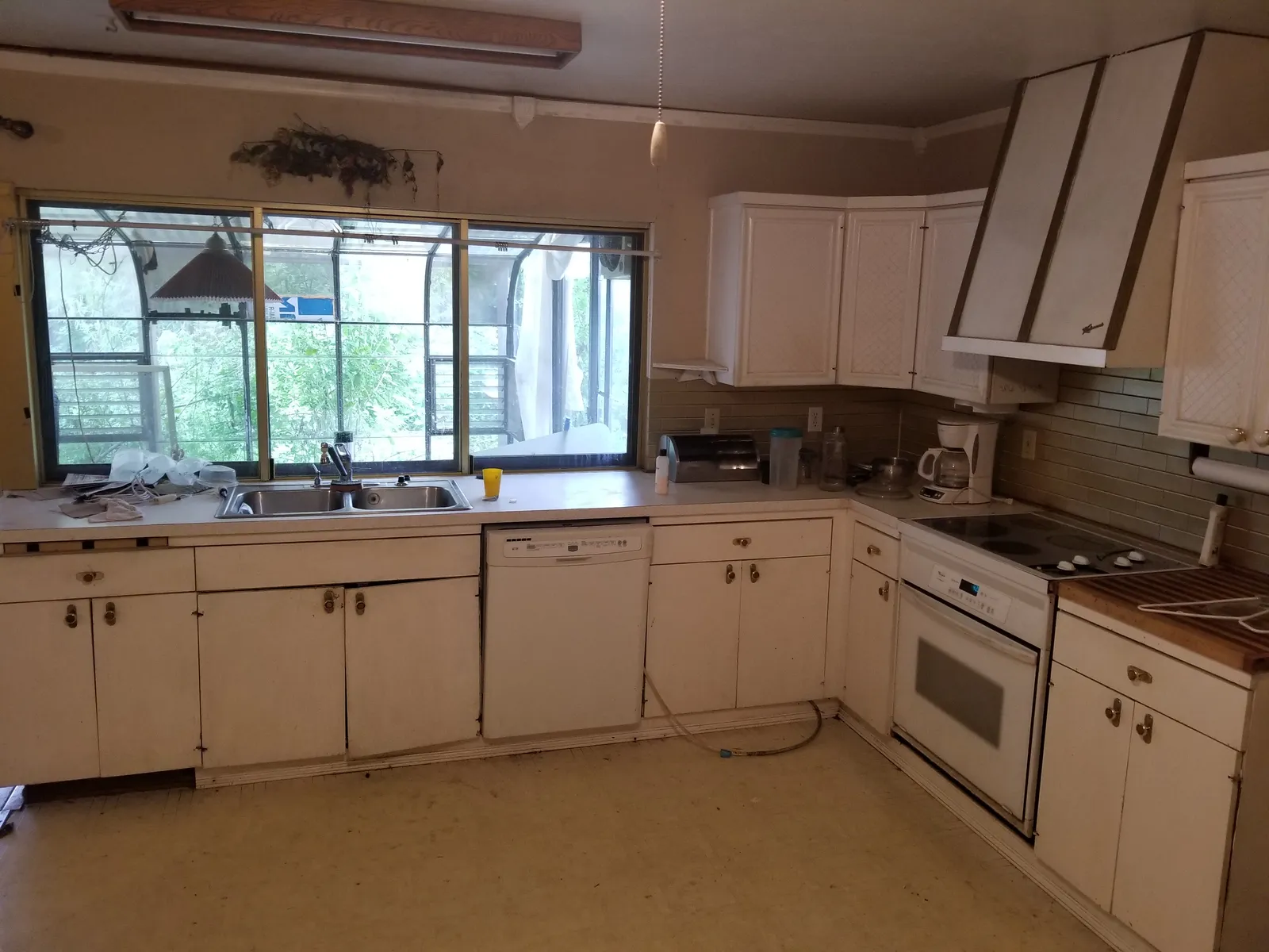 L-shaped kitchen with window over the sink — before renovation